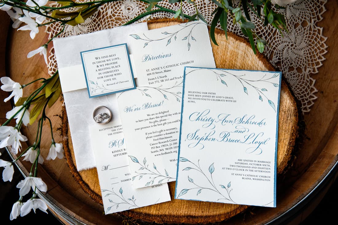 An assortment of wedding stationery on a wooden coin